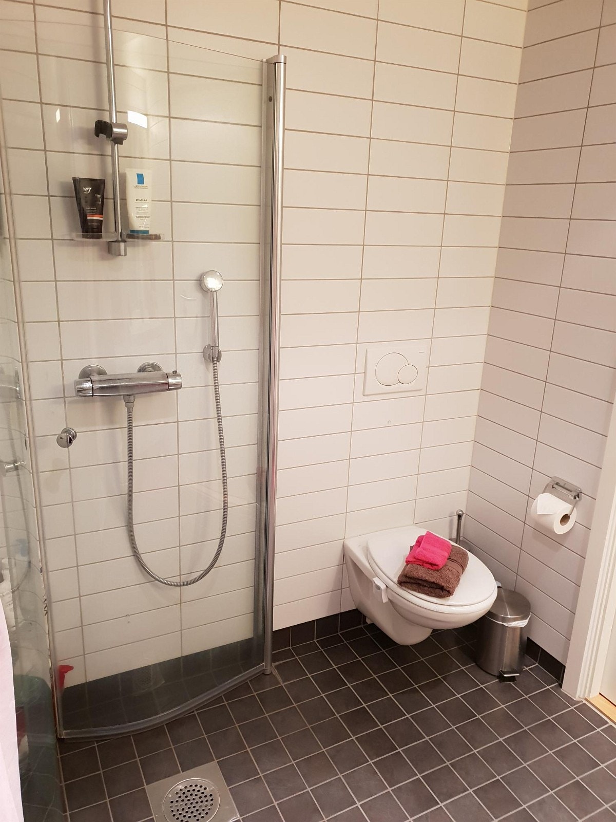 Delikat flislagt bad med dusj, vegghengt toalett, servant, varmekabler, downlights og opplegg for vaskemaskin. Galleribilde