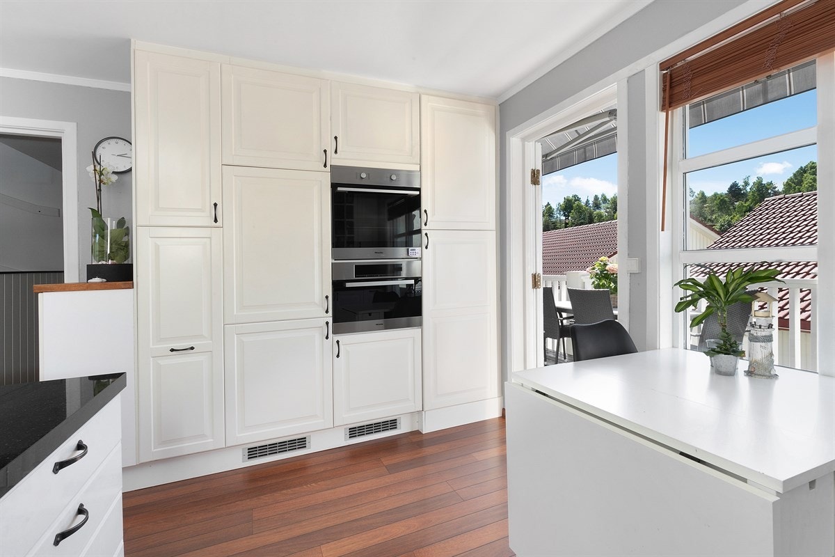 Videre er kjøkkenet utstyrt med flere vitrineskap, og nye, integrerte hvitevarer i form av nedsenkbar ventilator, induksjonstopp, stekeovn, dampovn, kjøl/frys og oppvaskmaskin. Galleribilde