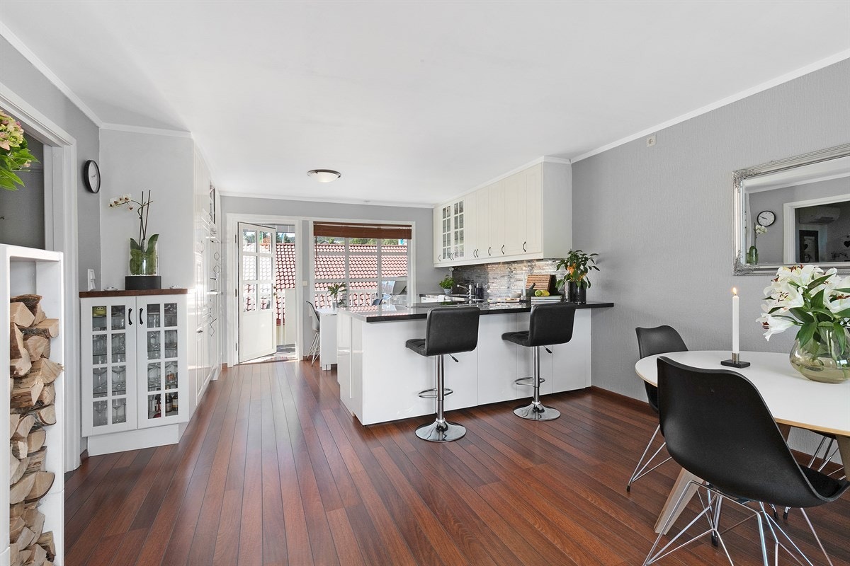 Kjøkkenet ligger i åpen løsning mot spisestue og stue, og sammen utgjør de et sosialt og smakfullt allrom med funksjonelle arbeidsflater og gode møbleringsmuligheter. Galleribilde