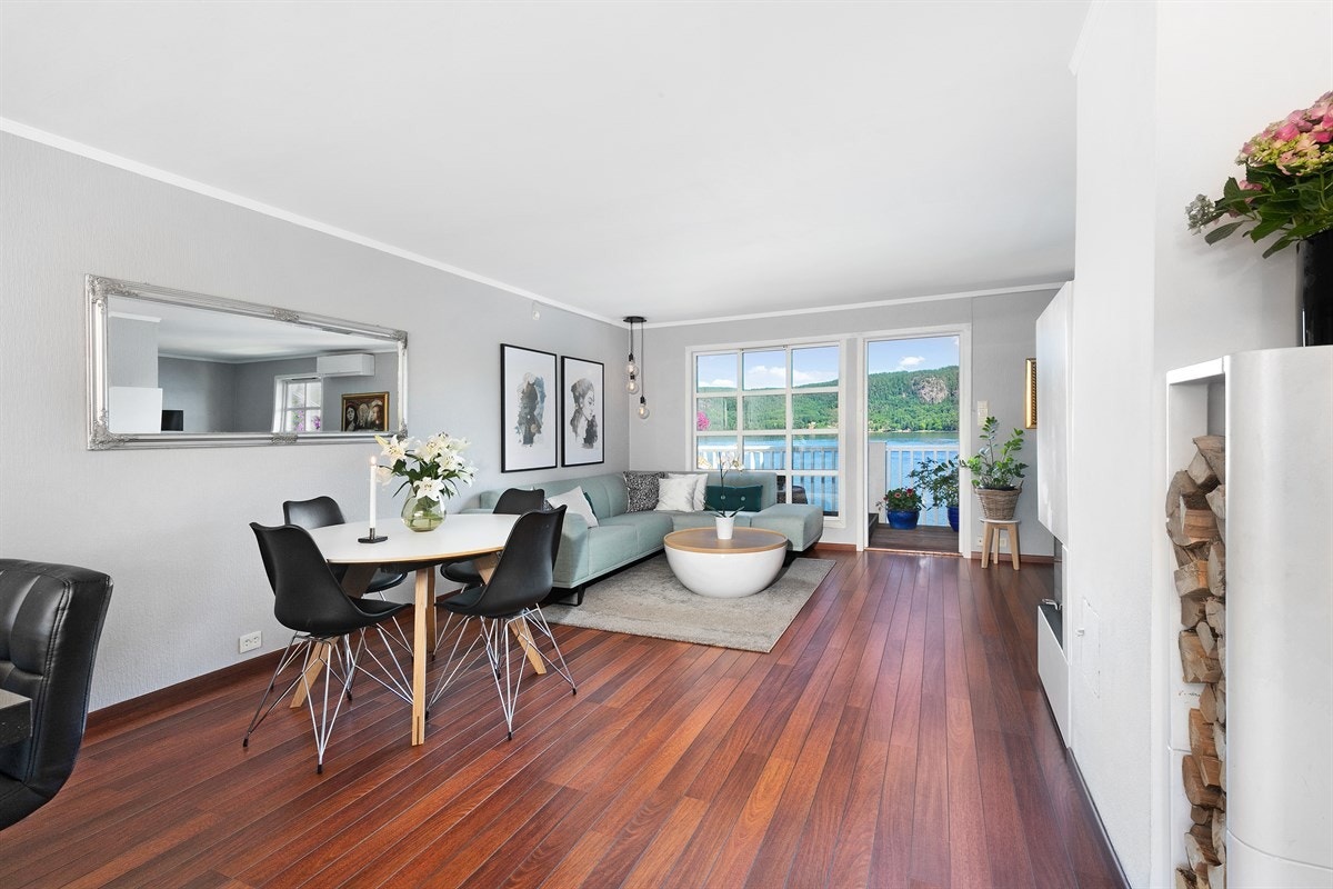 Allrommet har eksklusivt skipsgulv, lyse veggflater og en nyere peis med glassdører. Galleribilde