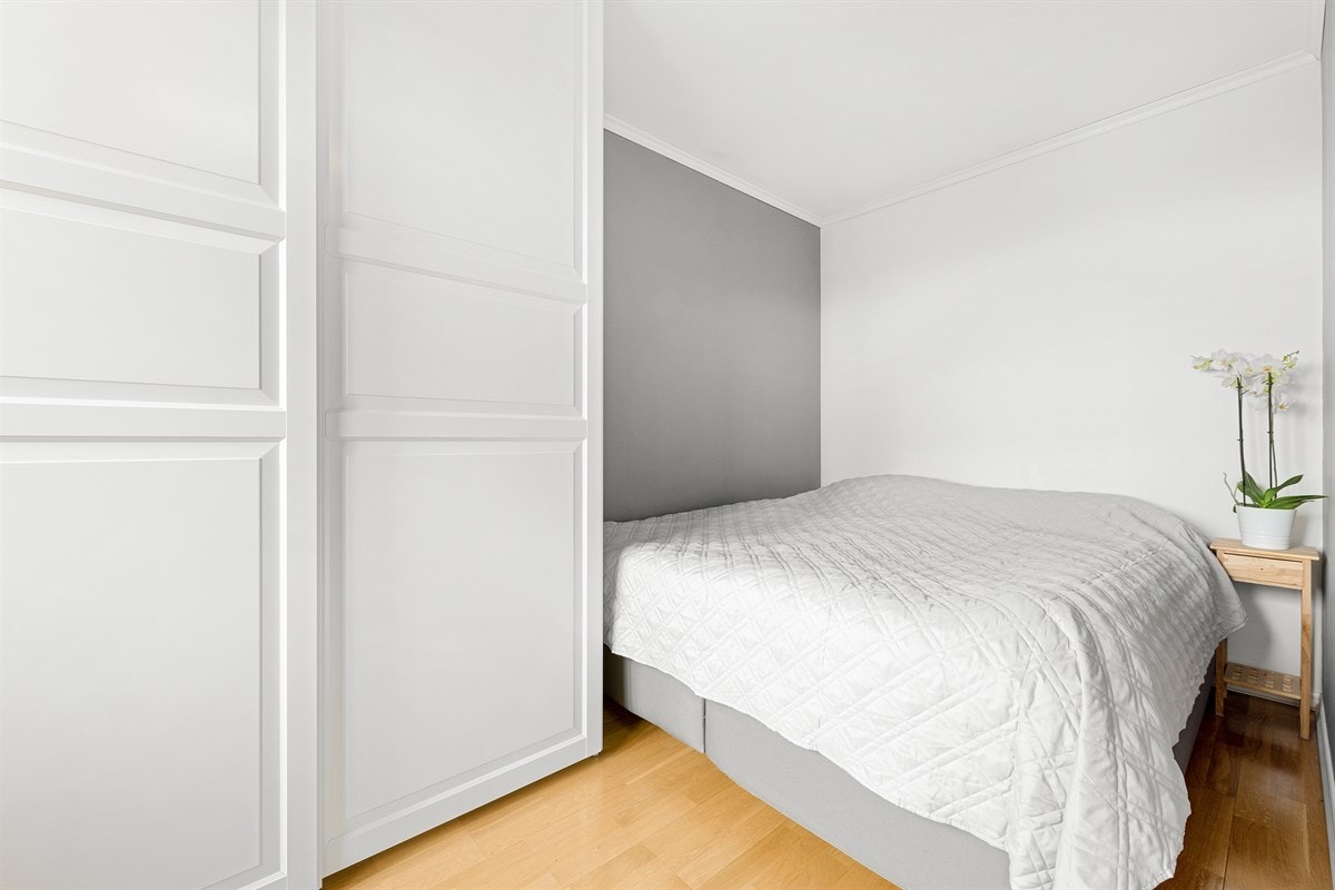 Soverom med plass til dobbeltseng og garderobeskap, samt lyse og delikate overflater Galleribilde