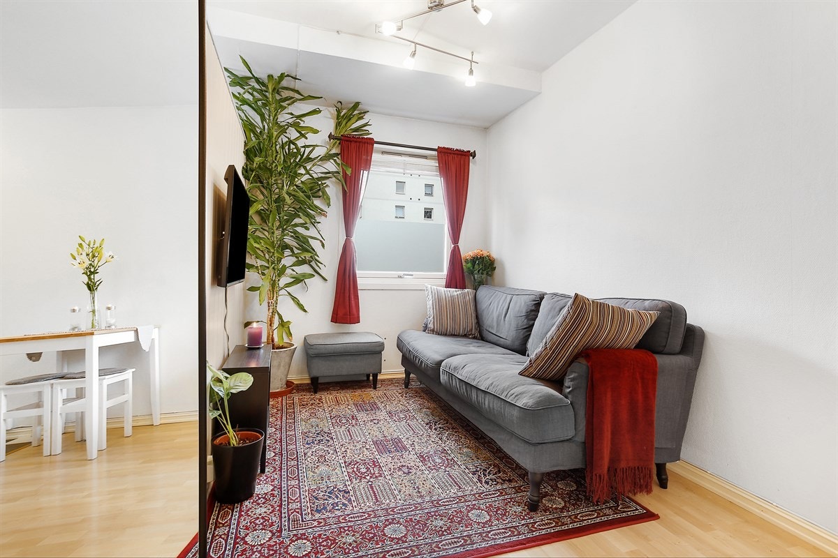 Stue med vindusflater ut mot grøntarealer. Galleribilde