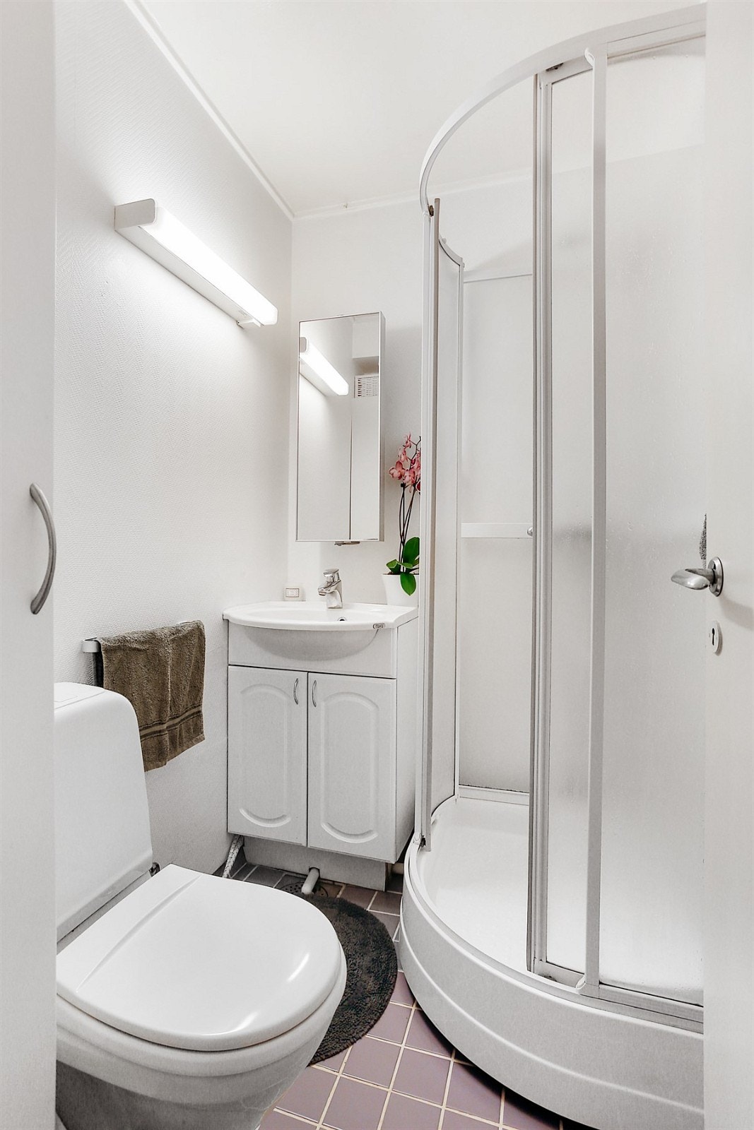 Flislagt bad. Praktisk med dusjkabinett. Servant med underskap og overskap med speil, samt wc. Galleribilde