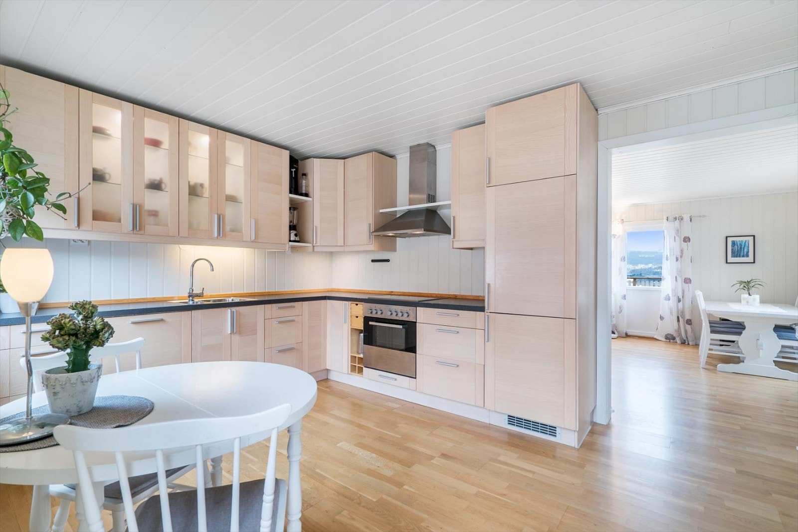 Romslig kjøkken med kjøkkeninnredning med integrerte hvitevarer - utgang til den store altanen også herfra Galleribilde