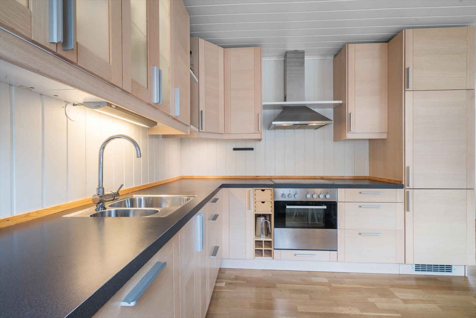 Romslig kjøkken med kjøkkeninnredning med integrerte hvitevarer - utgang til den store altanen også herfra Galleribilde