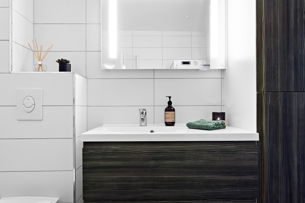 Badet er innredet med dusjnisje, vegghengt toalett, servant med servant skap og tilhørende høyskap. Galleribilde