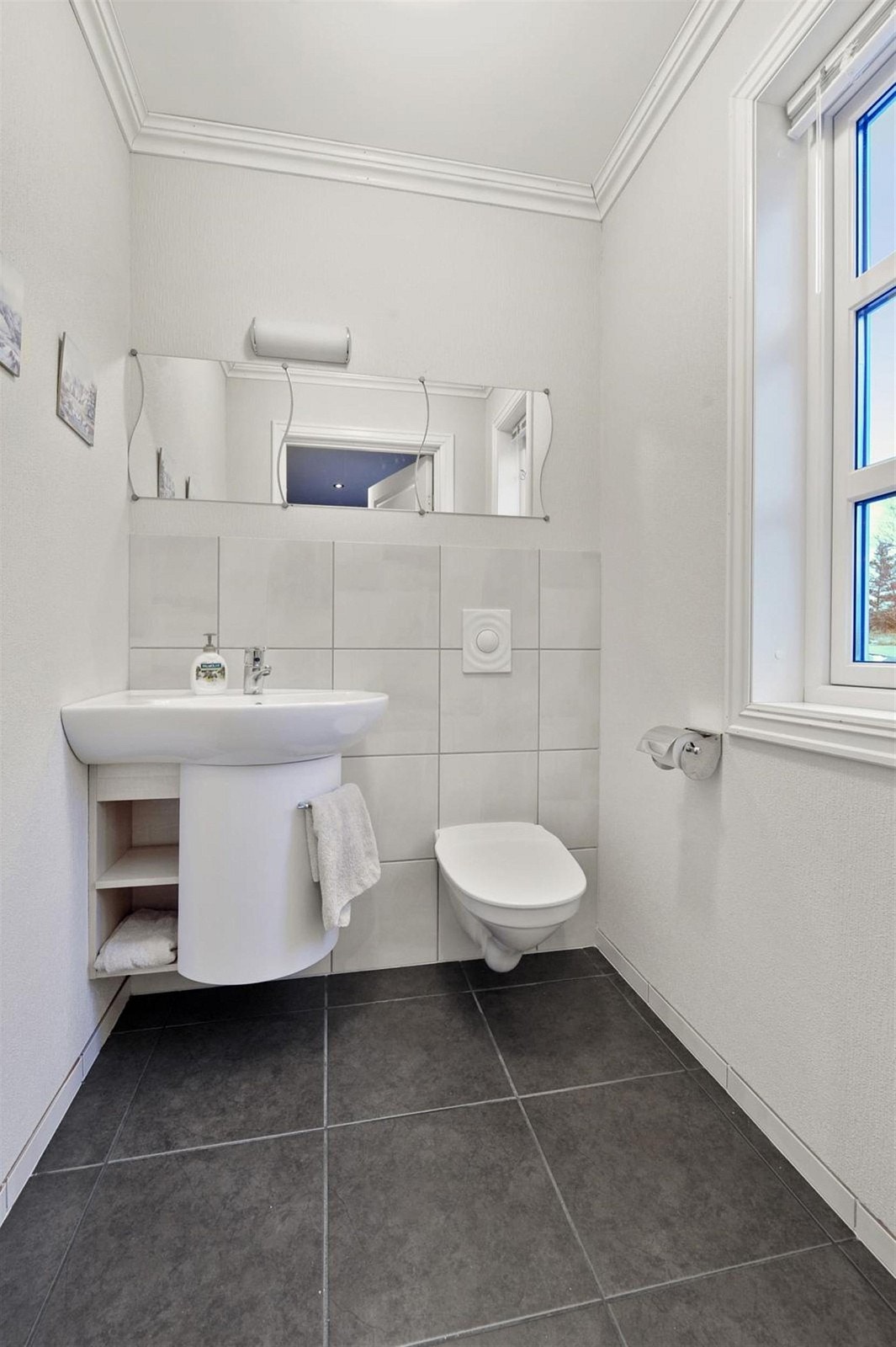 WC tilliggende gang med toalett, servant og speil med belysning. Galleribilde