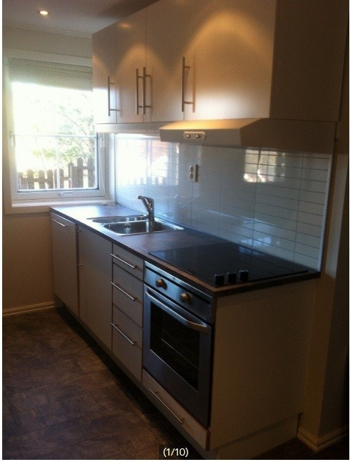 Kjøkken med oppvaskmaskin, platetopp, stekeovn, vifte og skap Galleribilde