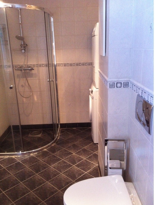 Stort bad med dusjkabinett, WC og vaskemaskin Galleribilde