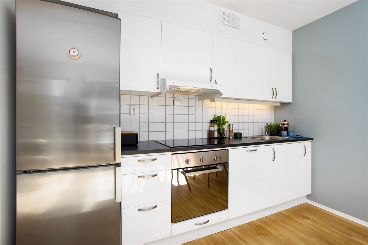 Flott kjøkkeninnredning fra Drømmekjøkken med høyglans fronter, overskap med belysning under. Galleribilde