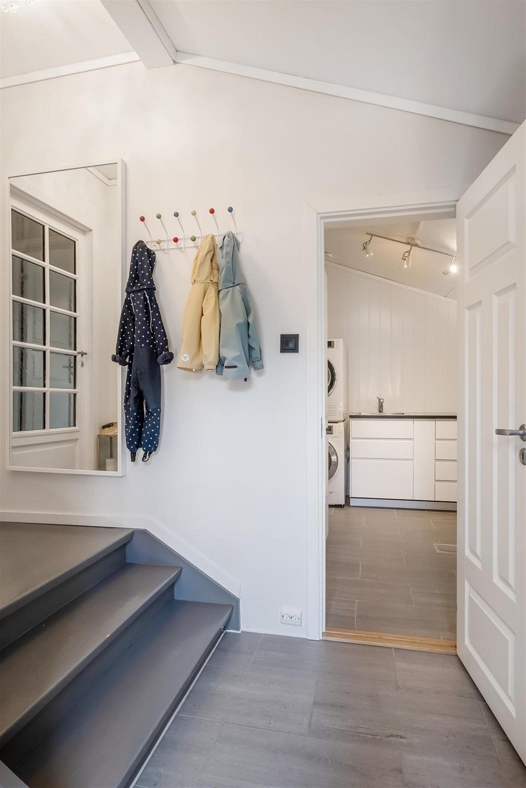 Romslig entré med fliser og varmekabler på gulv, oppheng for klær og sko. Galleribilde