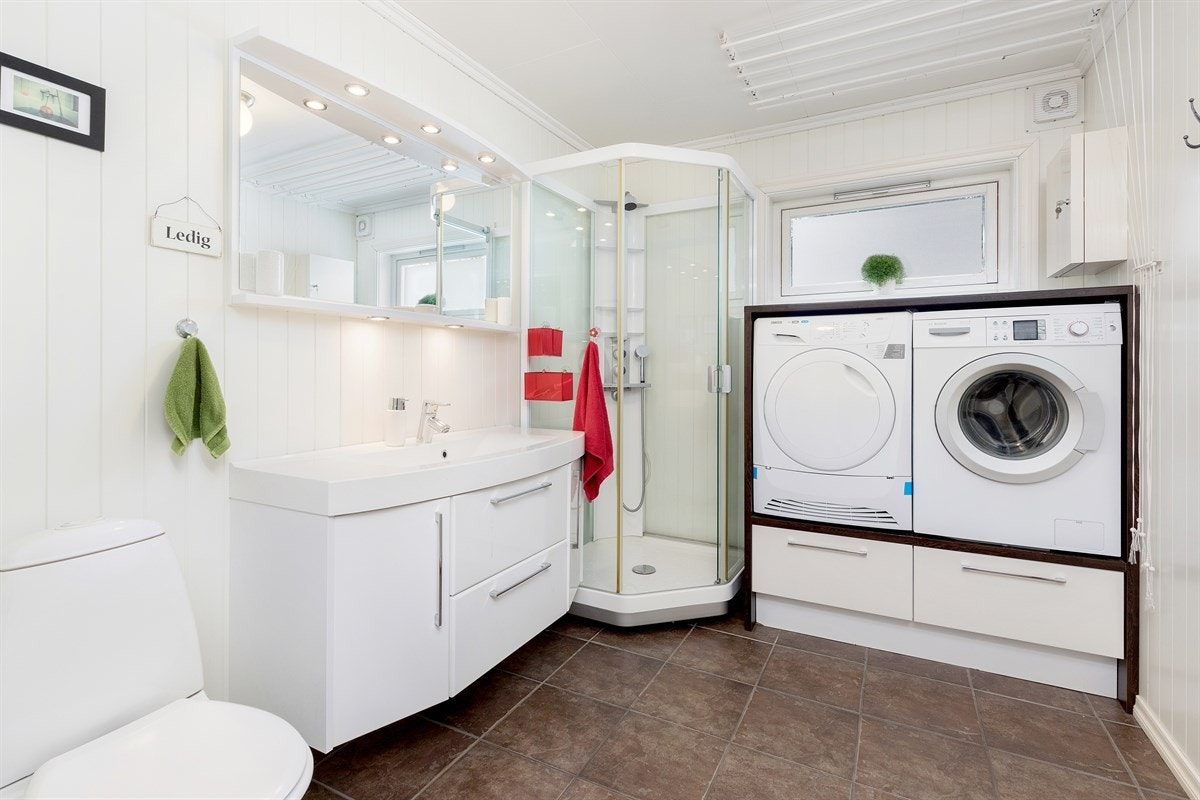 Romslig flislagt badegulv med varmekabler. Panel på vegger Galleribilde