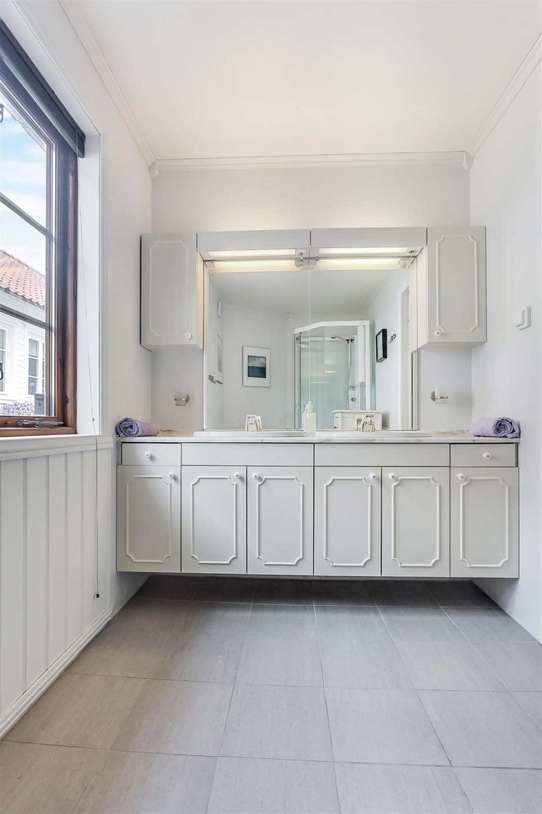 Badet er av god størrelse med fliser på gulv og varmekabler. Galleribilde