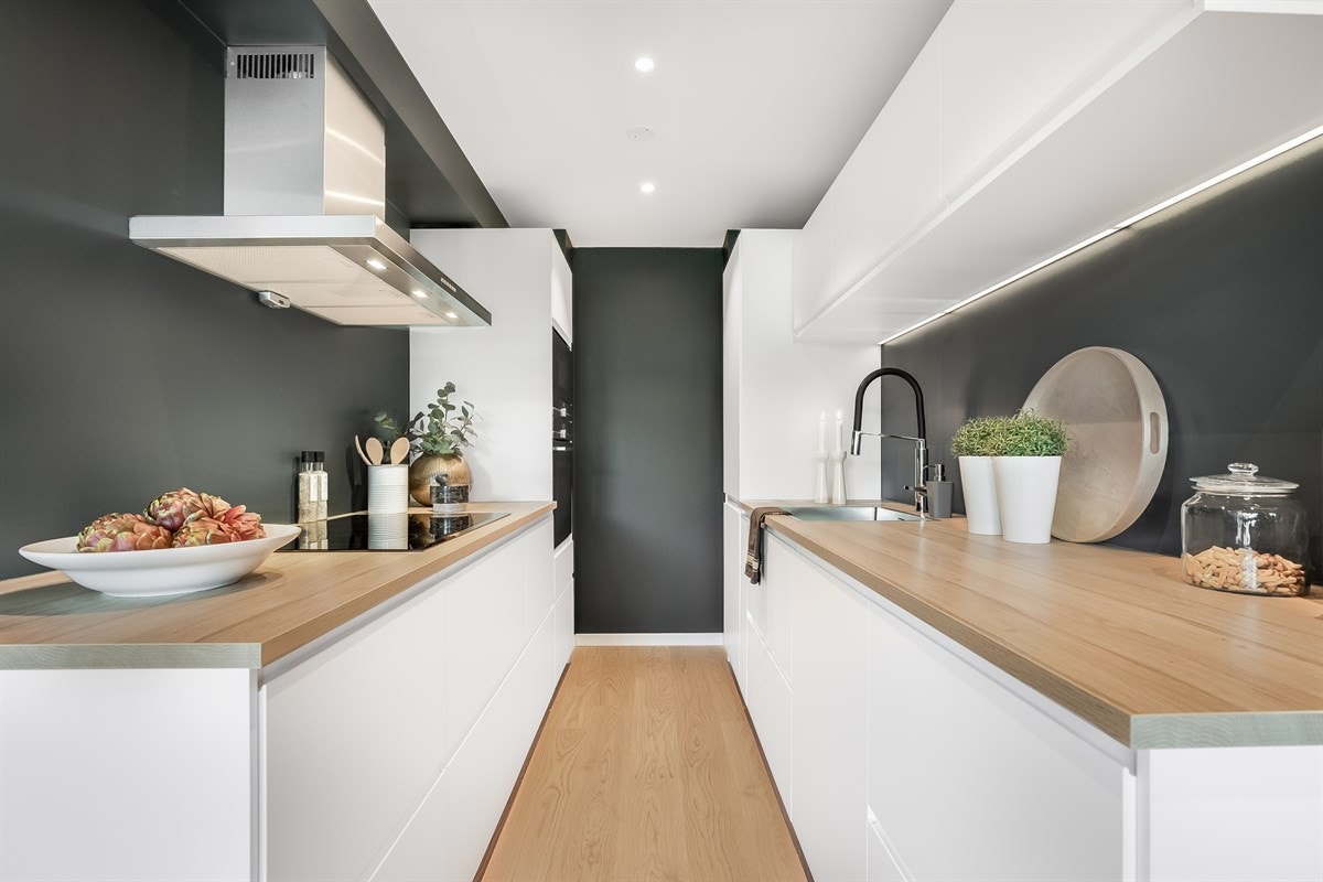 Kjøkkeninnredningen er i hvit utførelse med slette fronter og laminat benkeplate. Det er rikelig med skap og benkeplass, Galleribilde