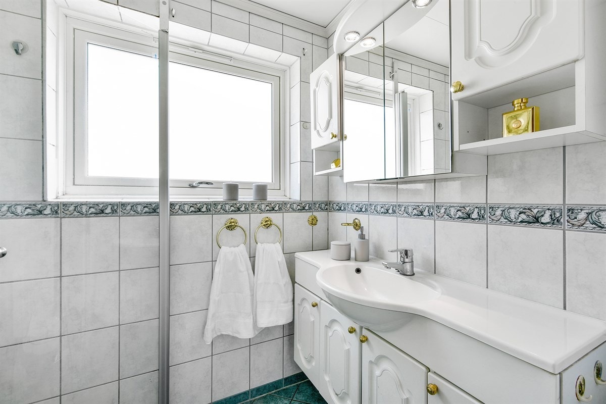 Innredningen har profilerte, hvite fronter og består av servantskap, veggskap og speilskap. Galleribilde