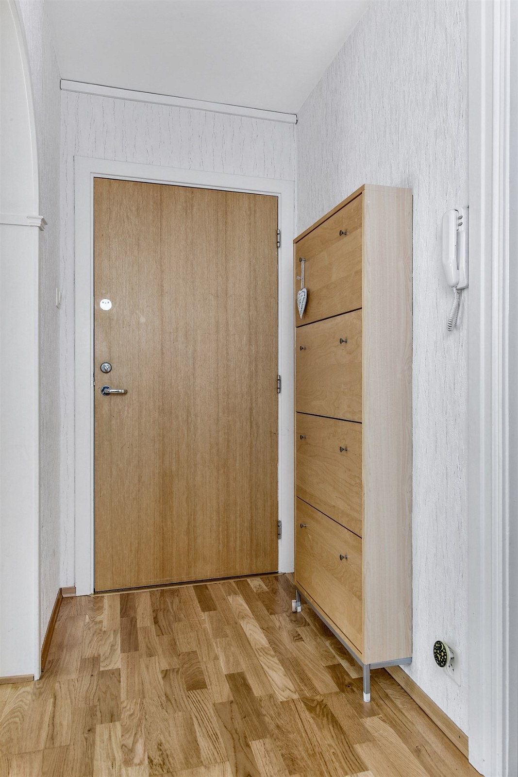 Entreen gir et trivelig førstemøte med leiligheten med parkett på gulv og mønstertapet på veggene. Galleribilde