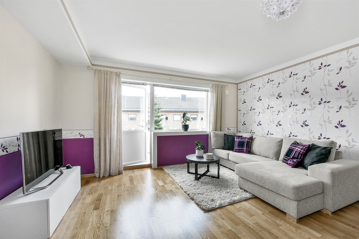 Stuen har eikeparkett på gulv og vegger med dekortapet, i kombinasjon med malte flater. Galleribilde