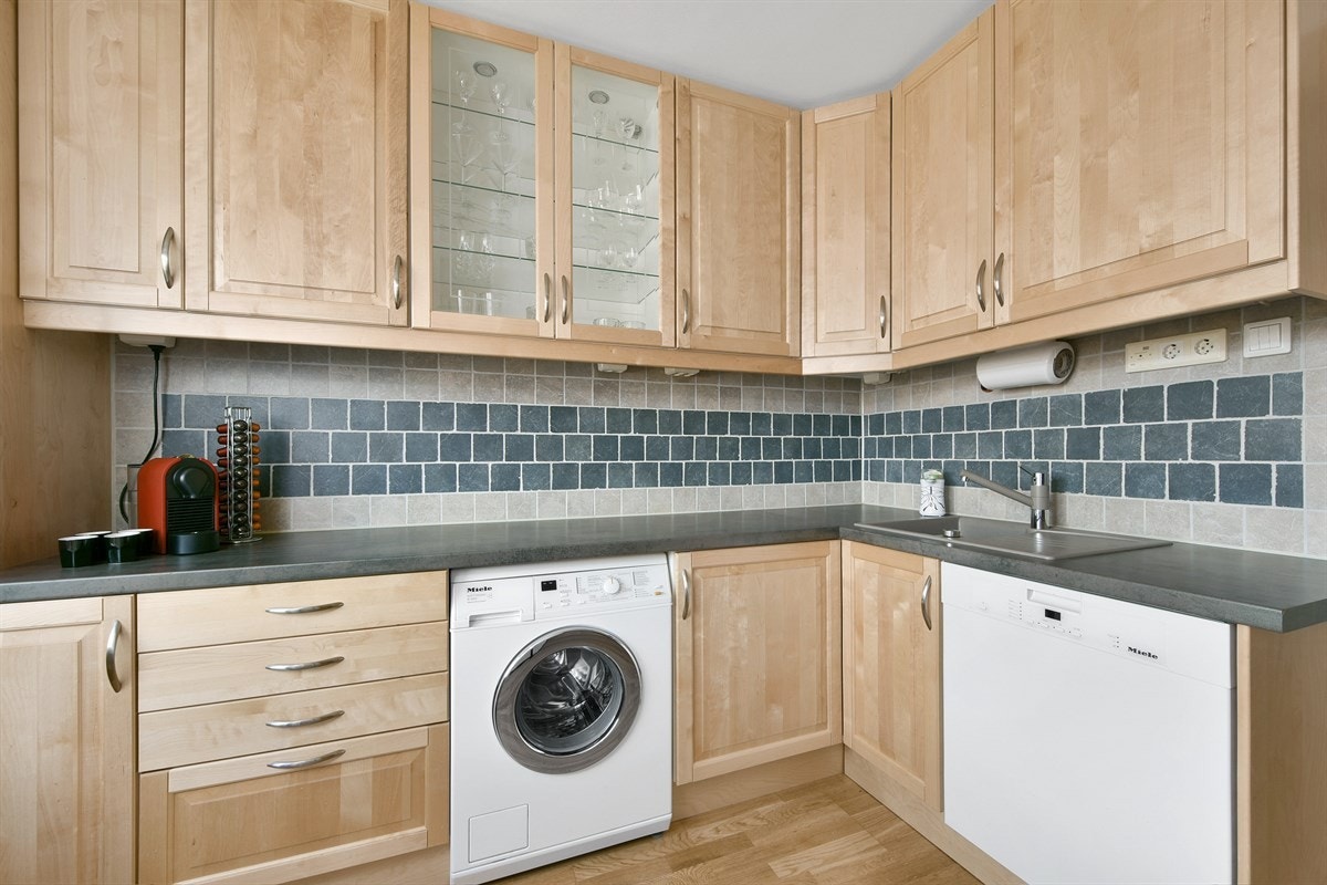 Rommet har parkett på gulv, tapetsert fondvegg og spiseplass ved utsiktsvindu. Galleribilde