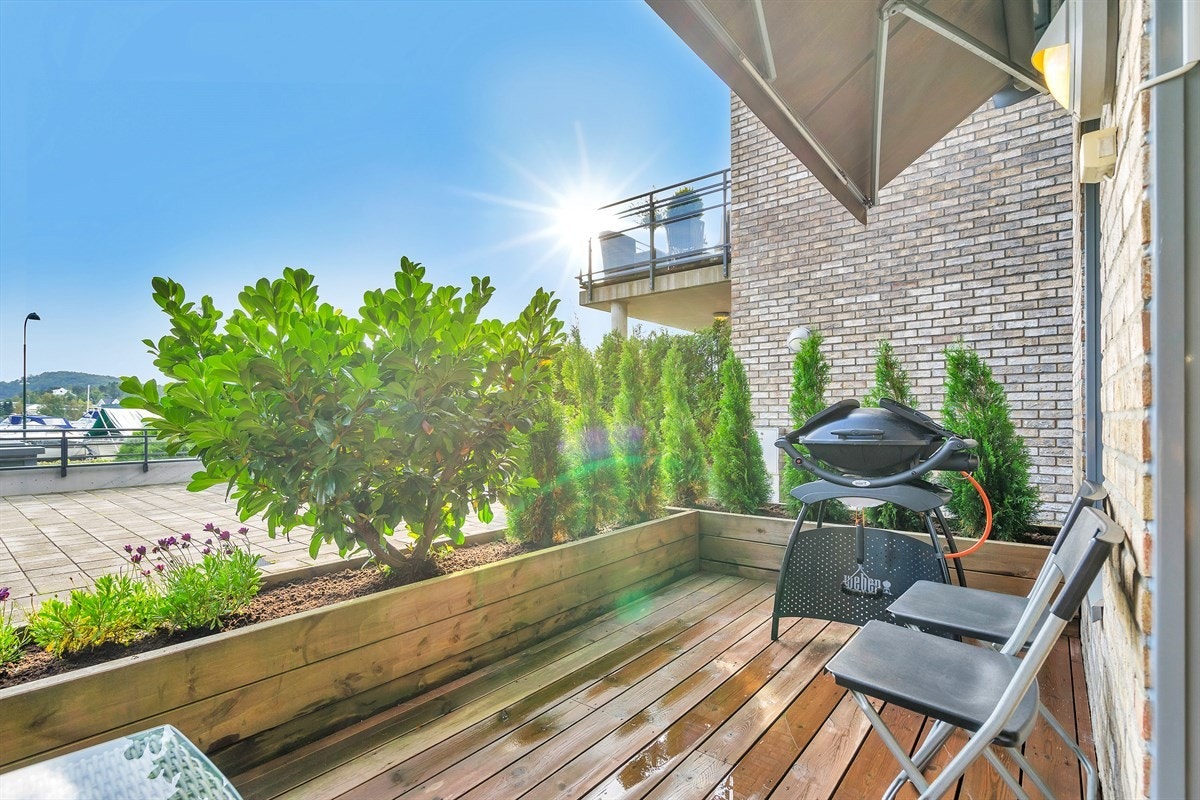 Terrassen har utsyn mot fellesarealer og sjøen Galleribilde