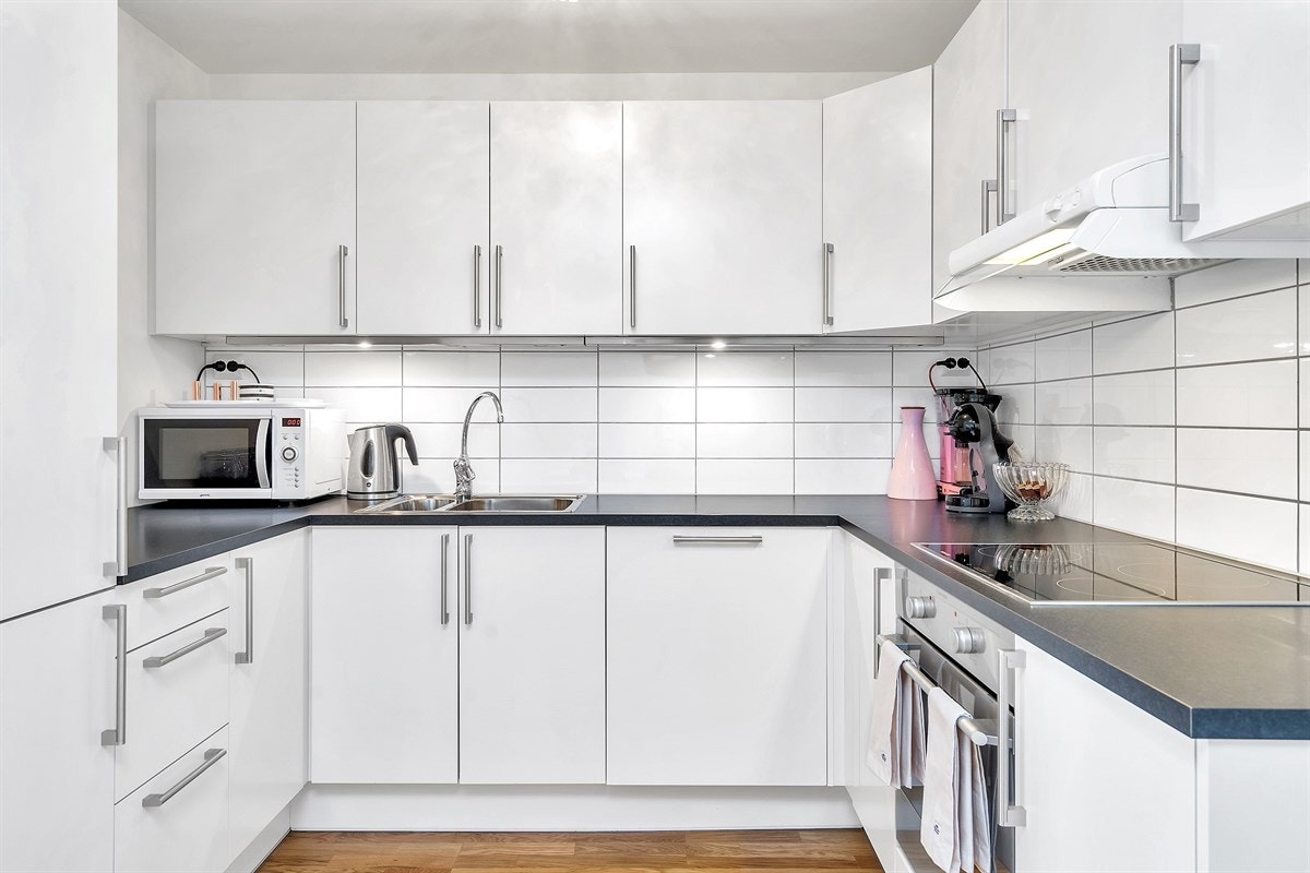 Delvis åpne kjøkkenløsning med integrerte hvitevarer Galleribilde