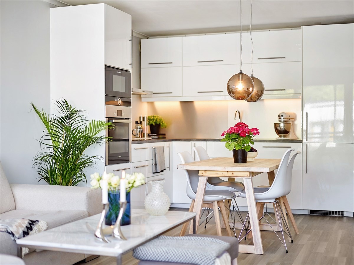 Moderne kjøkkeninnredning fra 2016 med lyse fronter og integrerte hvitevarer som koketopp, komfyr, oppvaskmaskin og kjøl/frys Galleribilde