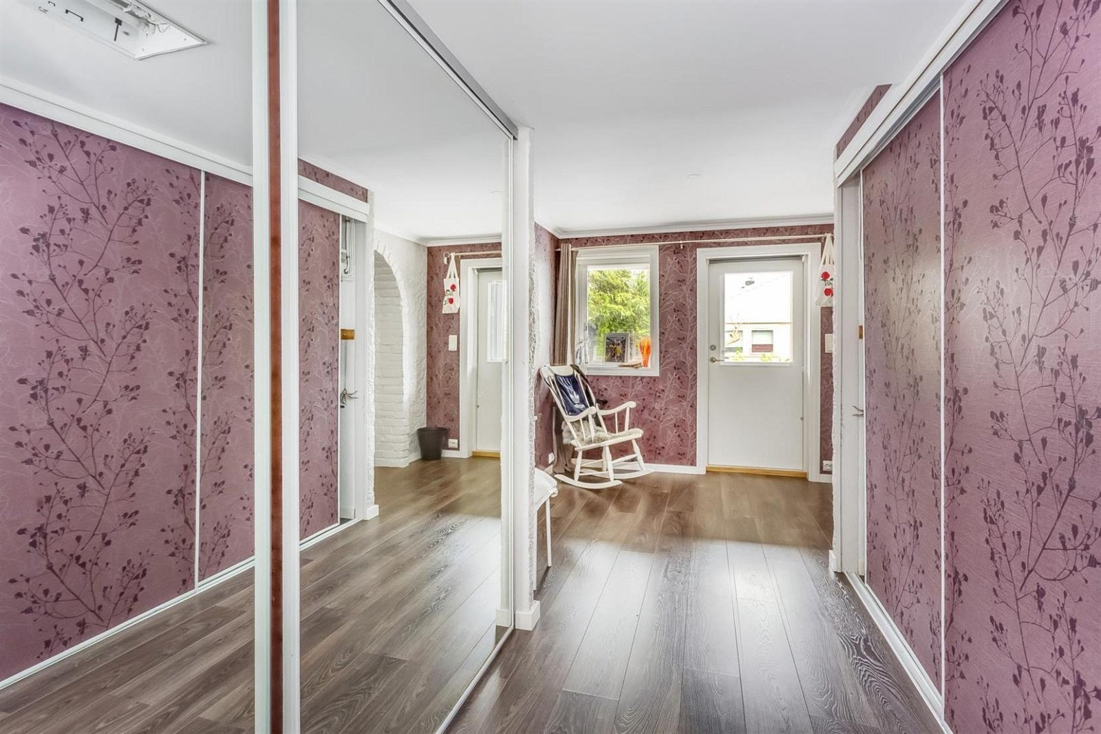 Gang med garderobeskap på begge sider og utgang til bakgården med bassenget. Galleribilde