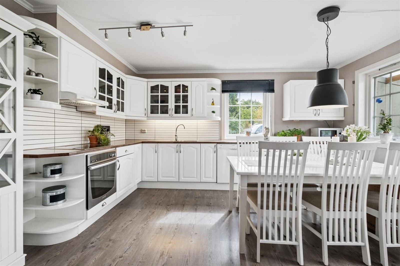 Kjøkkeninnredningen har hvite profilerte fronter i klassisk stil med laminat benkeplate. Galleribilde