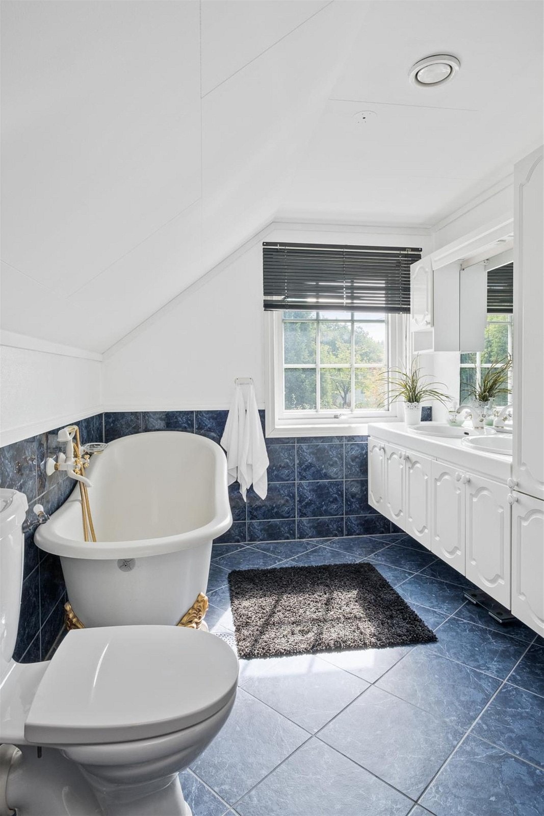 Bad 2.etg. er romslig med fliser på gulv og opp til brystningshøyde på veggene. Her er det et elegant badekar. Galleribilde