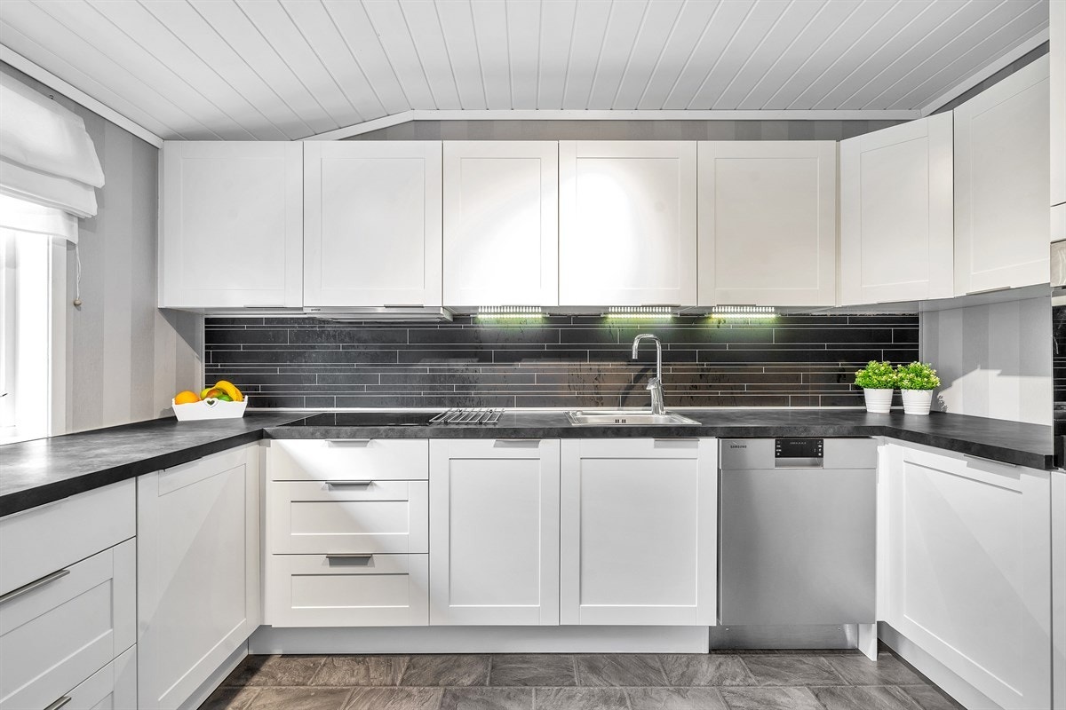 Kjøkken har mye innredning og stort vindu som gir mye lys Galleribilde