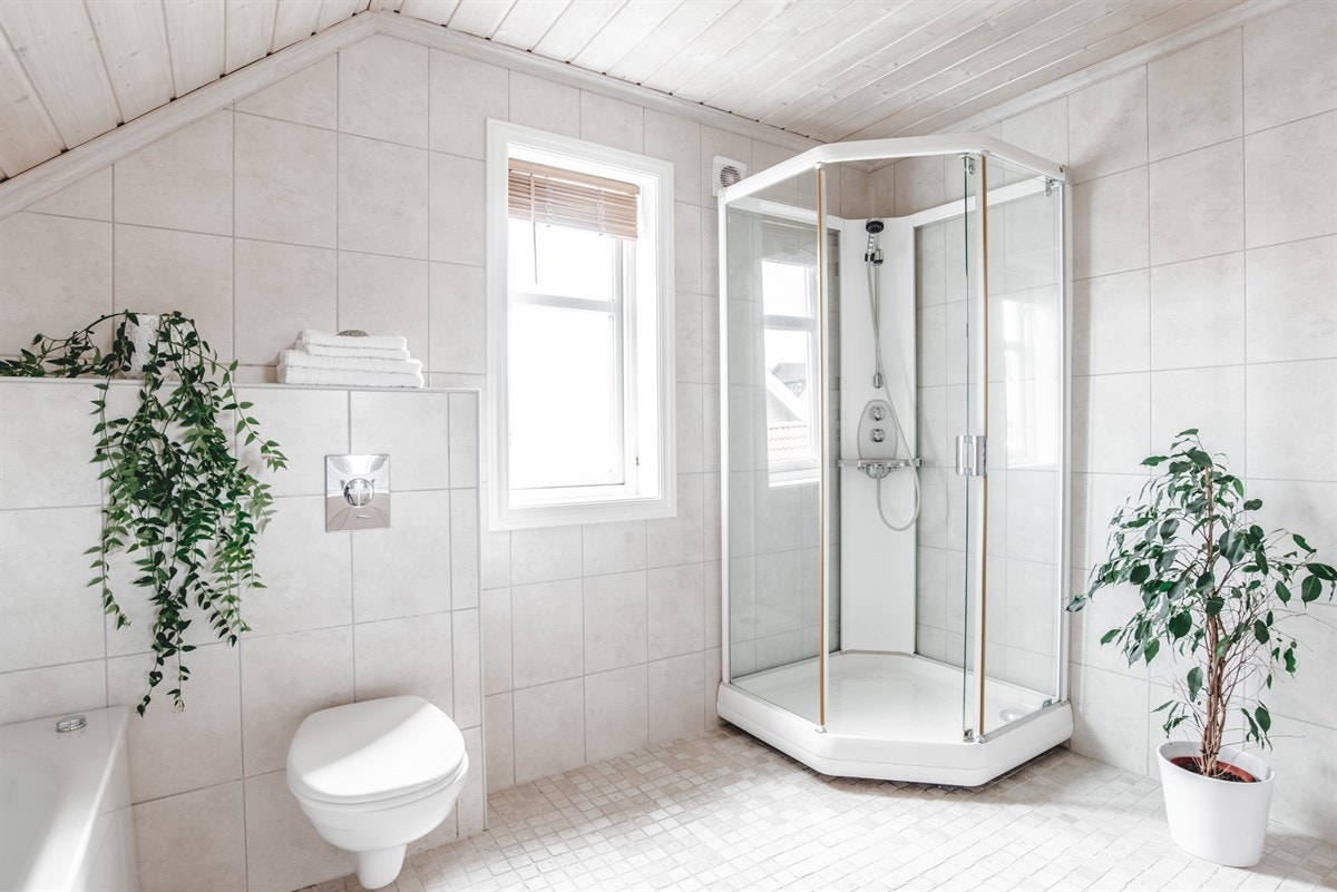 Badet er innredet med dusjkabinett, badekar, vegghengt toalett og servant med skap. Galleribilde