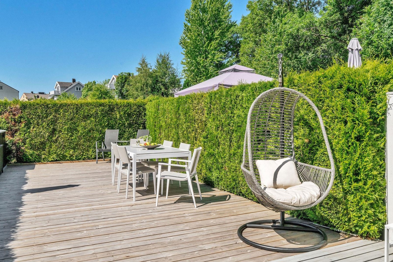 Rekkehuset har solrik uteplass omkranset av hekk Galleribilde