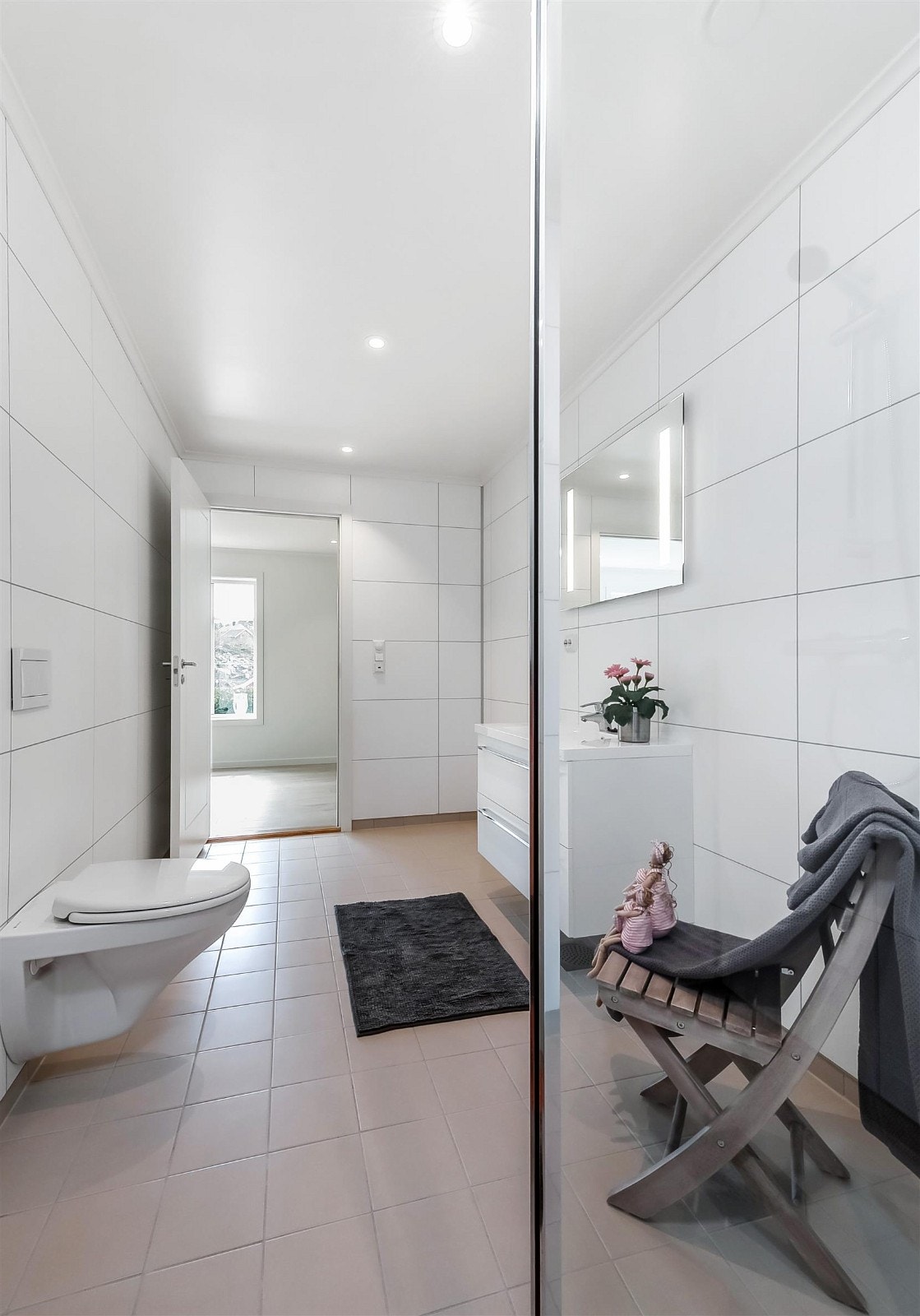 Begge badene har samme moderne innredning og vegghengt toalett. Badet i 1.etasje er praktisk plassert ved inngang og adkomst til garasje via vaskerom og hall. Galleribilde
