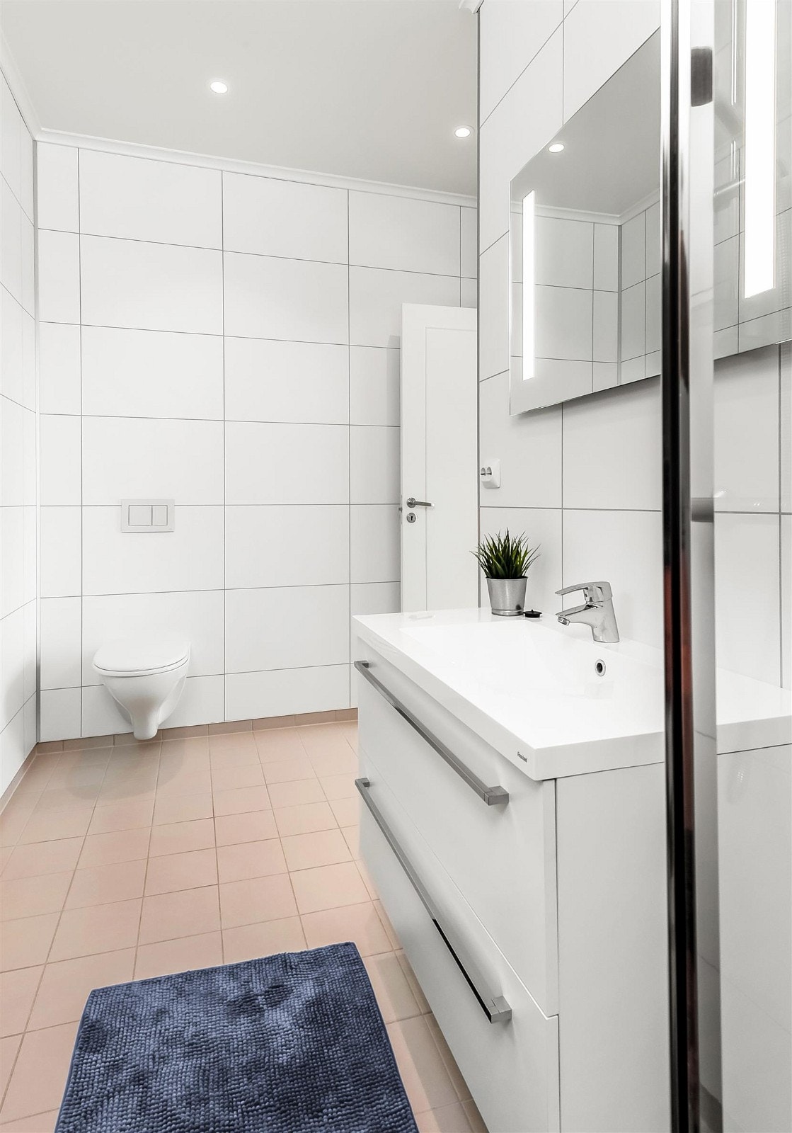 Badet i 2.etasje har flislagt gulv og plater med flisimitasjon på vegg. Moderne og pen innredning. Vegghengt toalett og spotter i tak. Galleribilde