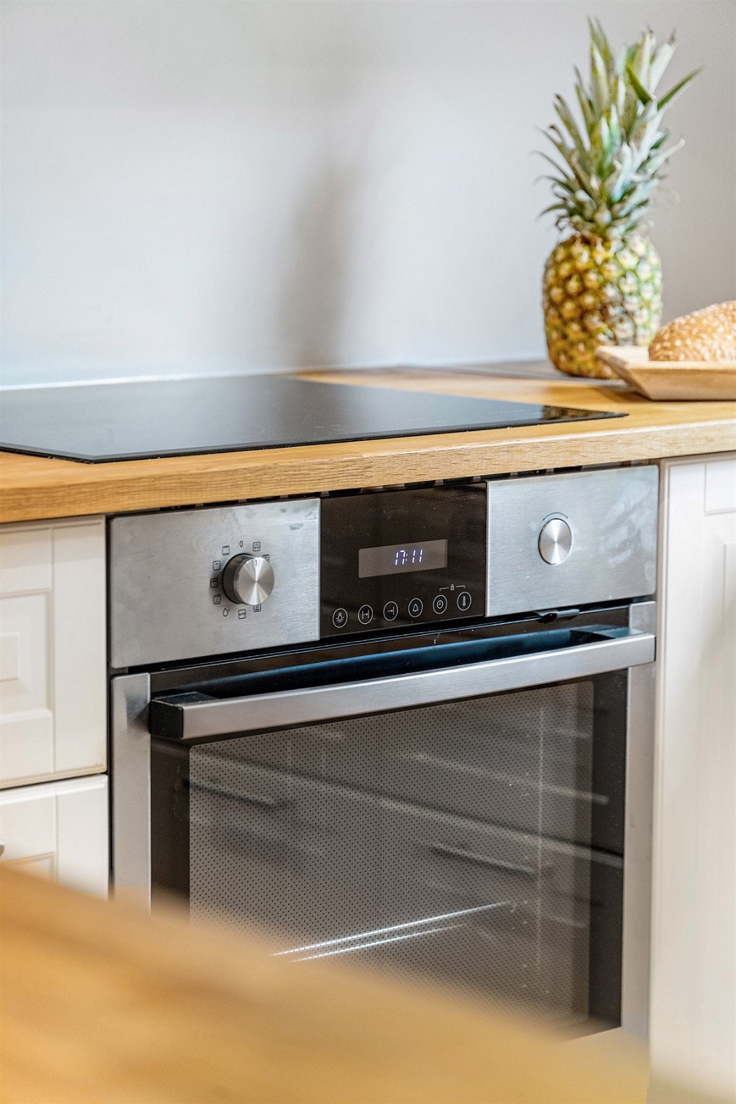 Kjøkkeninnredning med ett-speils lakkerte skapfronter, heltre benkeplate, 1 1/2 oppvaskkum, ventilator og innfelte hvitevarer som koketopp, stekeovn, oppvaskmaskin og frittstående kjøl/fryseskap. Galleribilde