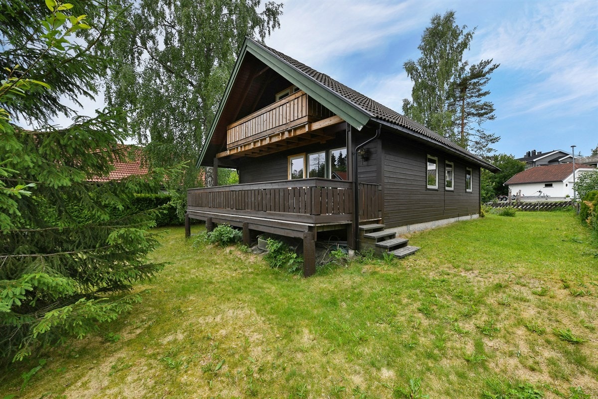 Prydbusker, hekk og store trær gir god skjerming til uterommet, og ekstra usjenert er det da eiendommen vender mot skogholt i bakkant. Galleribilde