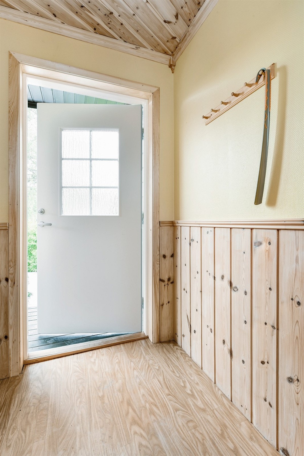 Entreen har belegg på gulv, vegger med trehvit brystning og gulmalte veggflater ellers. Galleribilde