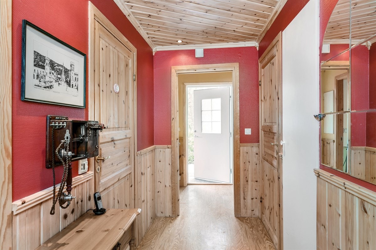 Boligen har en trivelig velkomstterrasse under tak, der en hvitmalt ytterdør med vindu leder til entré. Galleribilde