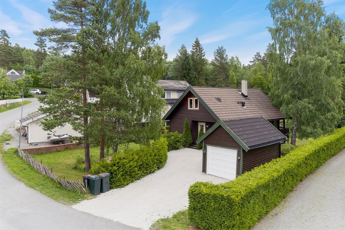 Det er parkering i en garasje med elektrisk port og biloppstillingsplasser på gårdsplass. Galleribilde