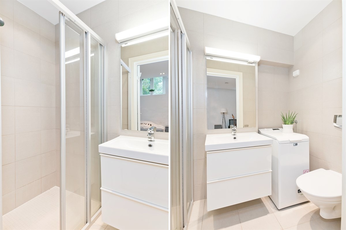 Badet har vegghengt toalett, servantskap i hvit stil, dusj og opplegg for vaskemaskin Galleribilde