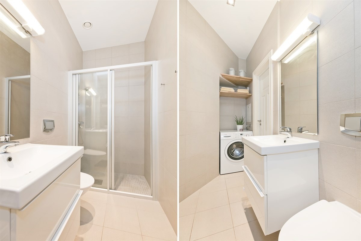 Lekkert flislagt bad med varmekabler og opplegg for vaskemaskin. Vegghengt toalett, servantskap i hvit stil og dusj. Galleribilde