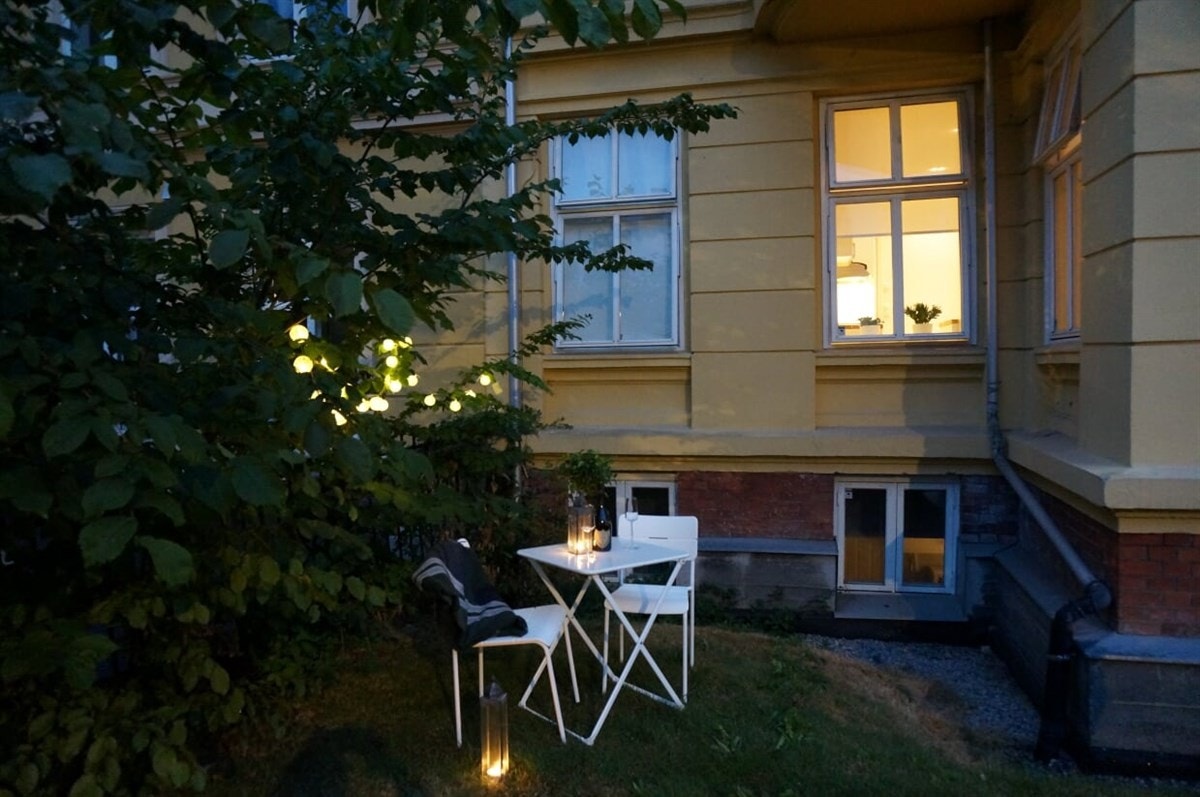 Stemningsfullt kveldsbilde som viser deler av forhagen og deler av leiligheten. Galleribilde