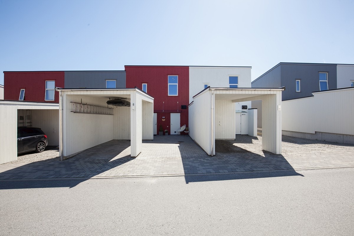 Fasade - parkering i carport og gårdsrom. Her er det lagt belegningsstein Galleribilde
