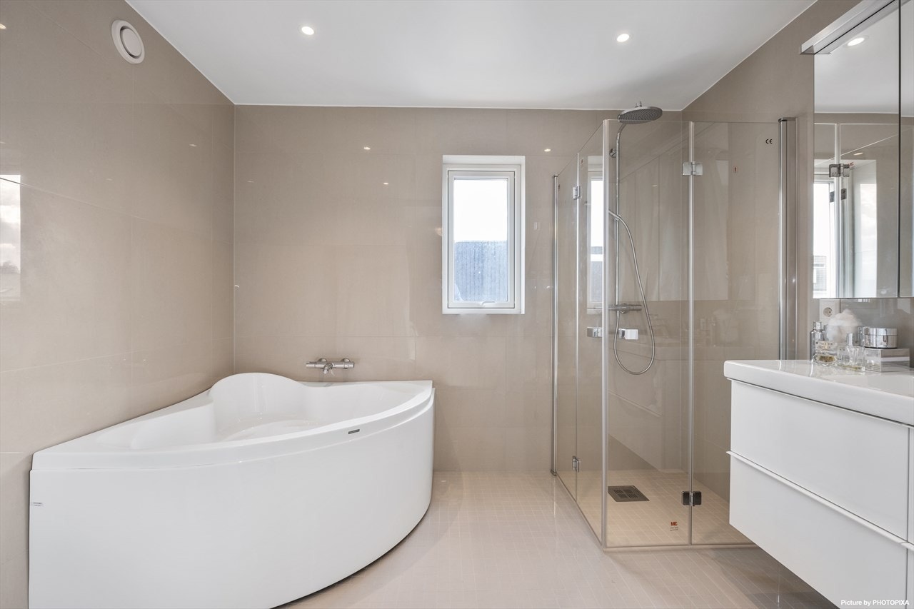 Badet som ligger i tilknytning til hovedsoverommet har både dusjnisje og badekar, hva mer kan man ønske seg? Galleribilde