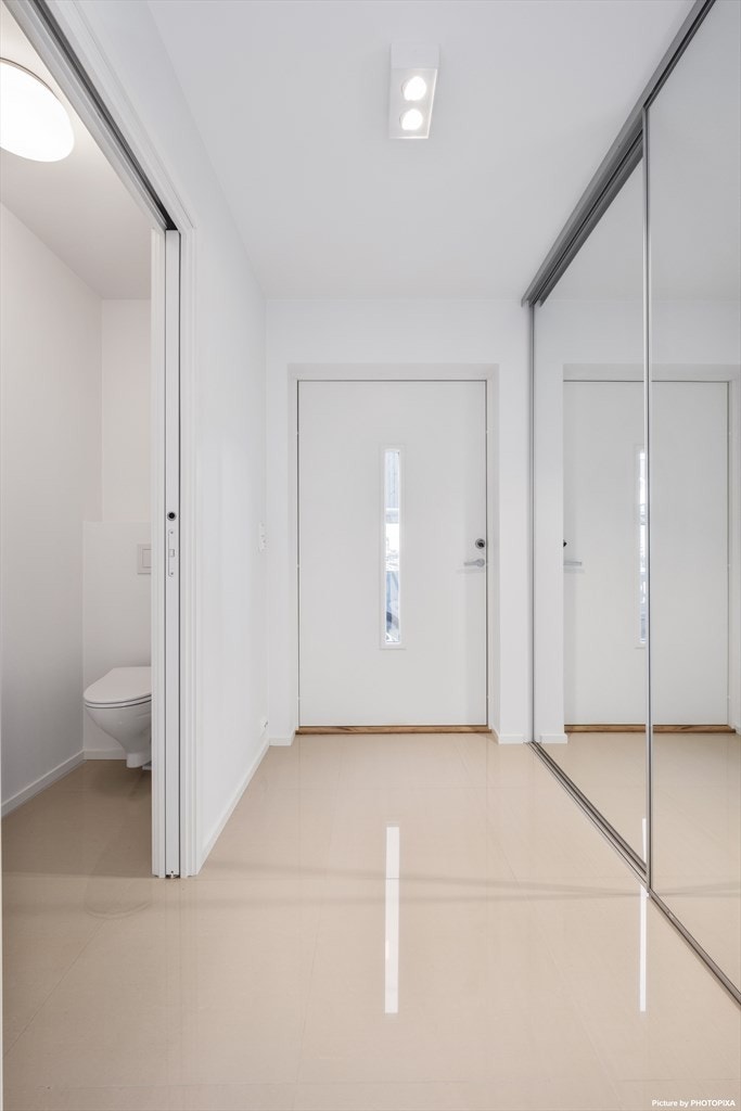 Hall med romslig garderobeløsning-gjestetoalett vegg i vegg. Galleribilde