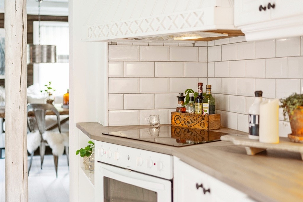 Integrerte hvitevarer og fliset sone mellom benk og overskap. Galleribilde