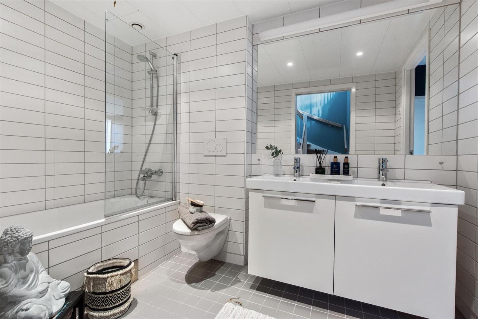 I boligens andre etasje finner du det andre badet, med innmurt badekar med innfellbar glassvegg. Dobbeltservant med underskap og innmurt speil. Vegghengt toalett. Galleribilde