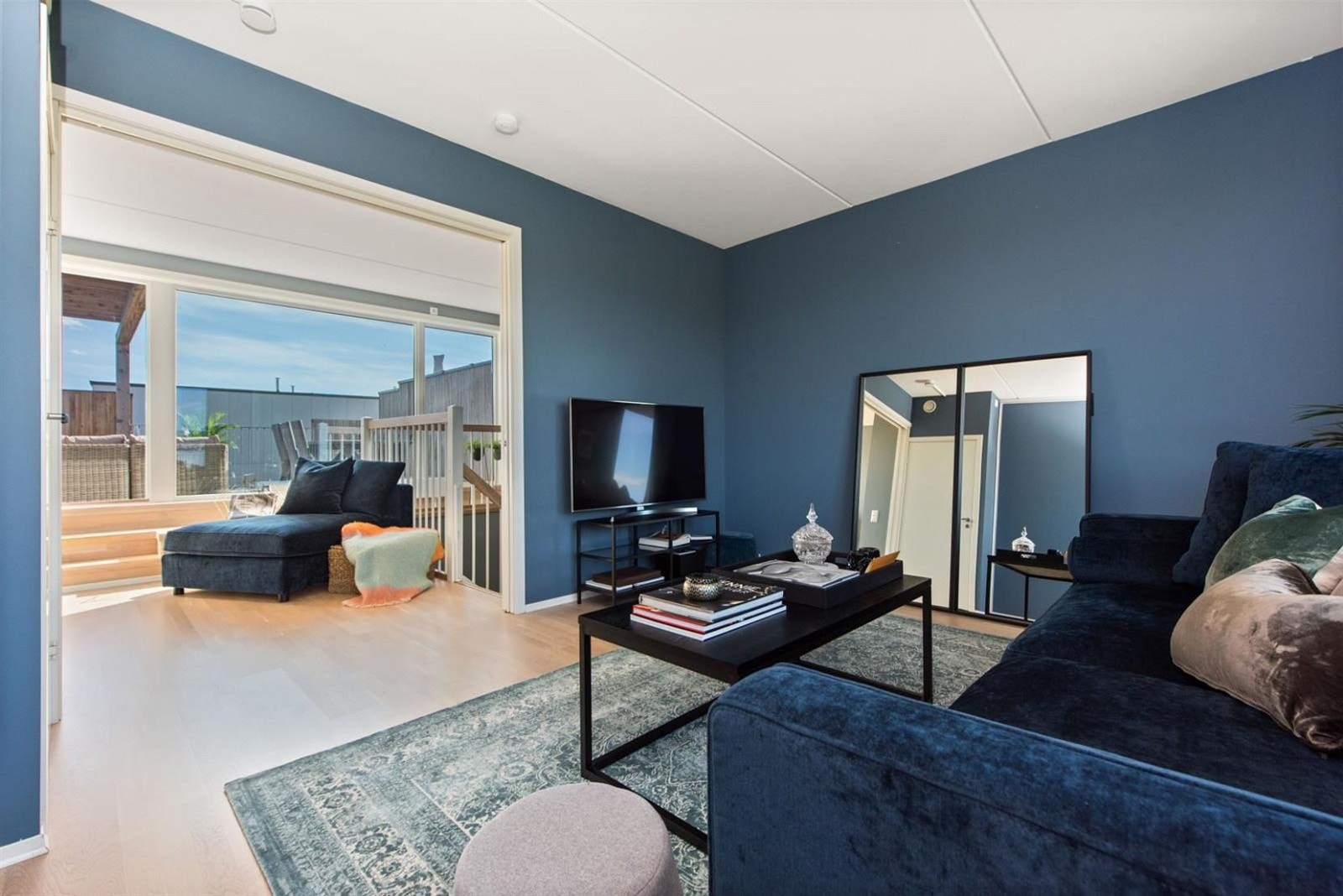 Lys stue med doble skyvedører mot lekestue som har utgang til takterrassen Galleribilde