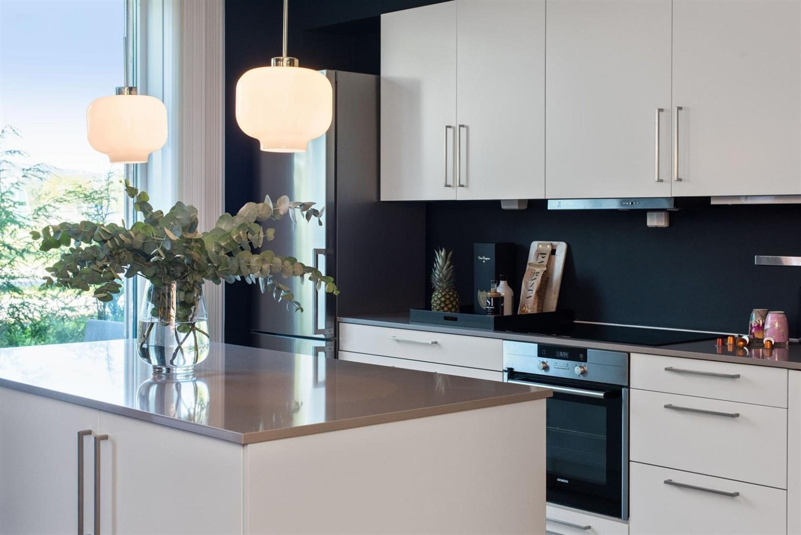 De store gulv-til-tak glassflater gir gode lysforhold på kjøkkenet. Galleribilde