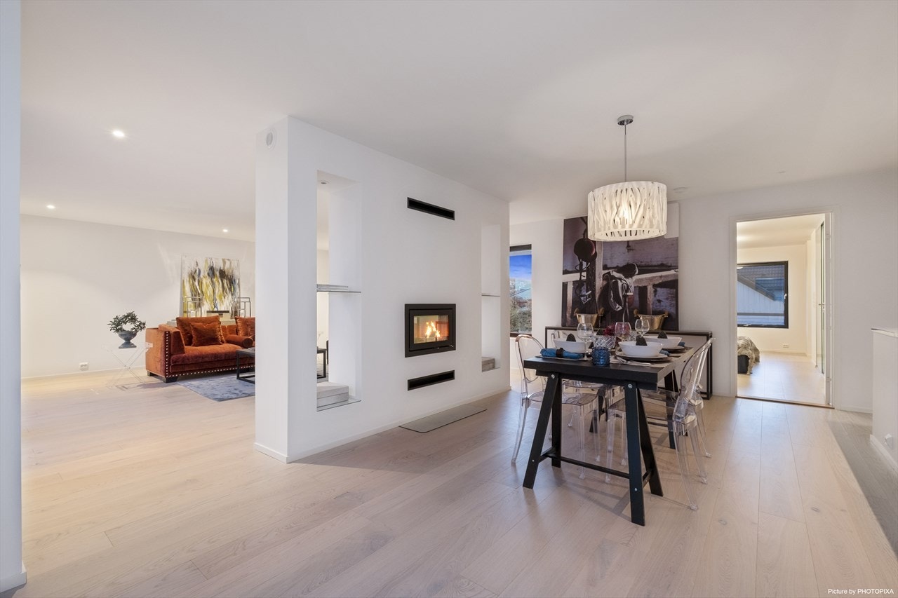 Veggen mellom kjøkkenet og stuen er et fint møbel til oppbevaring. Galleribilde