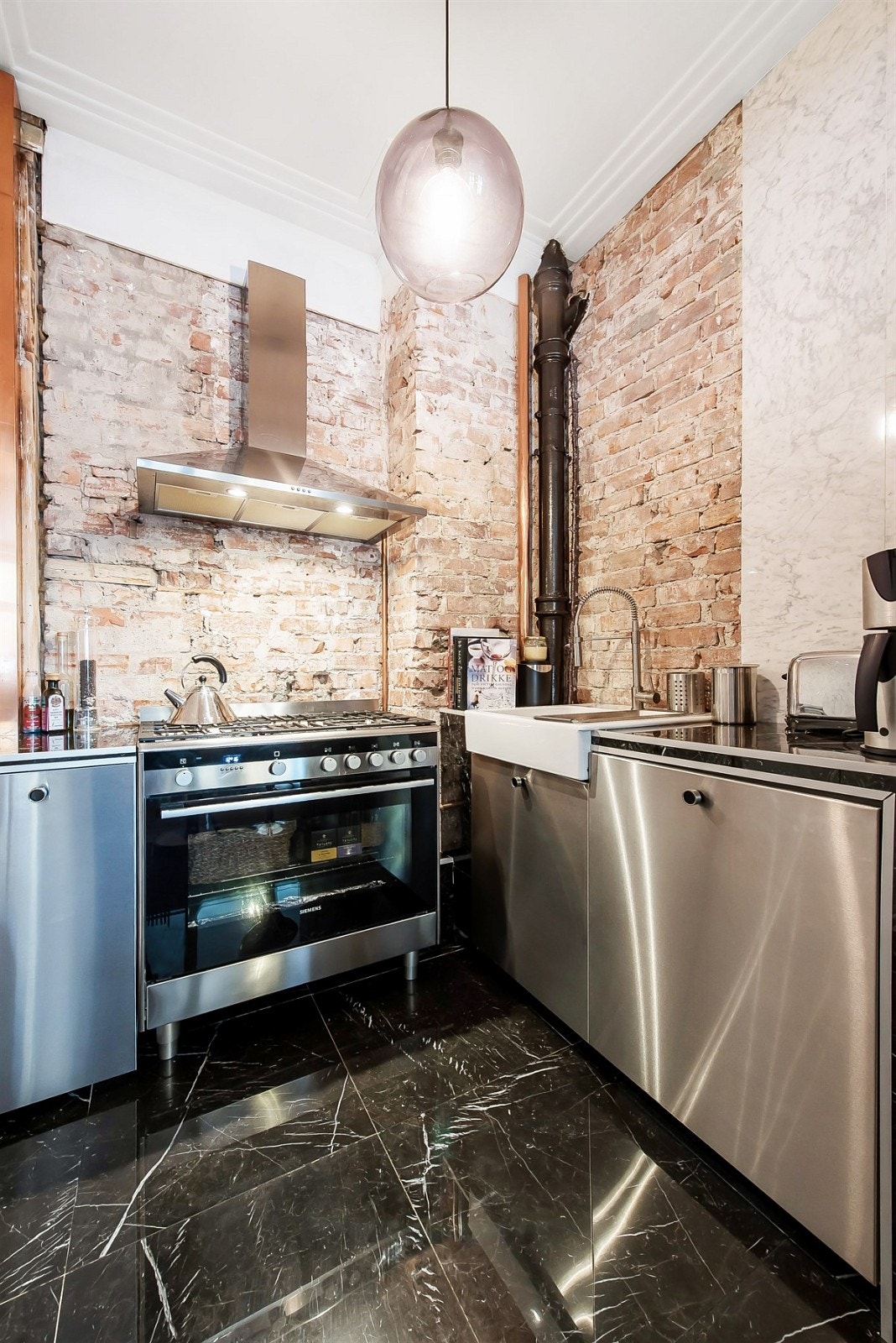 Opplegg for oppvaskmaskin og ventilatorhette som matcher resten a innredningen. På gulvet er det lagt flott naturstein. Galleribilde